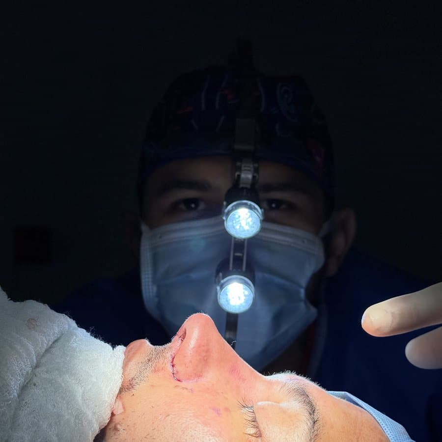Dr. Pedro León Amaya operando con luz frontal quirúrgica